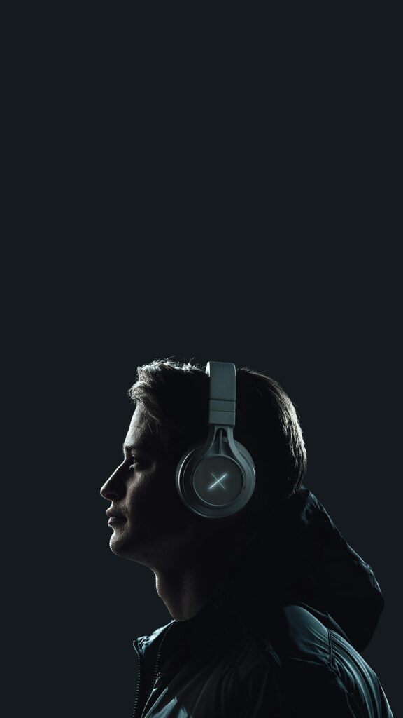 pexels-photo-3574678-3574678 Moody portrait of a young man wearing headphones against a dark studio backdrop.